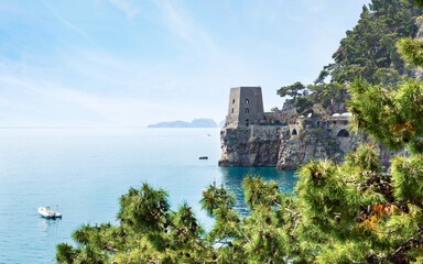 Ancient watchtower built into cliffs of Amalfi Coast near Positano, Italy, overlooking turquoise waters of Mediterranean Sea