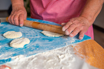 mom rolls out the dough for pies. High quality photo
