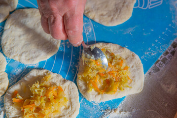 grandmother makes pies with cabbage from dough. High quality photo
