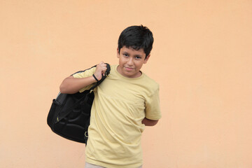 10-year-old Latino boy, excited and happy, uses his backpack with books to study and learn back to school