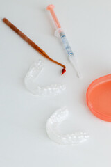 Dental whitening trays and gel applicator on white background