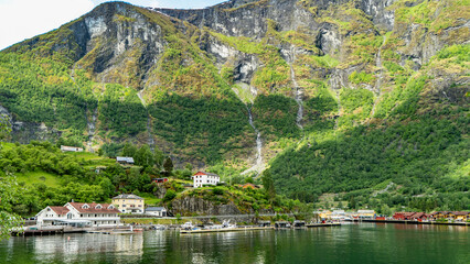 Flam village nestled beneath towering mountains on the Norwegian fjord