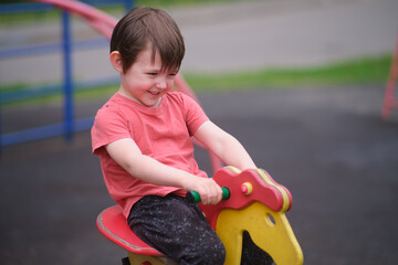 Little boy child having fun on a spring rider at playground outside. Child development and outdoor play concept. Youth park activity. A child aged 3 years