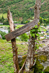 Wooden signpost for Brekkefossen waterfall in the Norwegian mountains