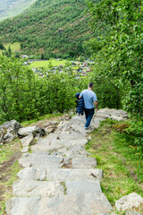 Person descending a stone path from a viewpoint overlooking Flam village