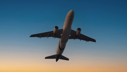 Airplane in the sky. Airplane in flight at sunset or evening sky. Commercial airliner silhouette in...