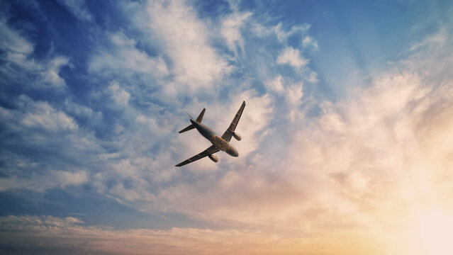 Airplane in the sky. Airplane in flight at sunset or evening sky. Commercial airliner silhouette in the colorful evening or night moon skies. Aircraft symbol of travel adventure global connectivity.