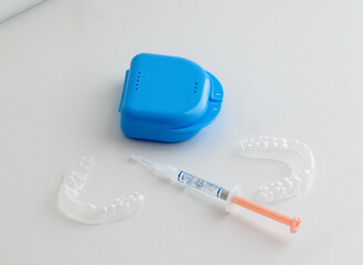 Dental whitening trays and gel applicator on white background