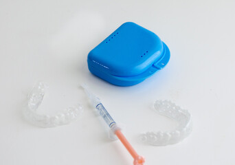 Dental whitening trays and gel applicator on white background	