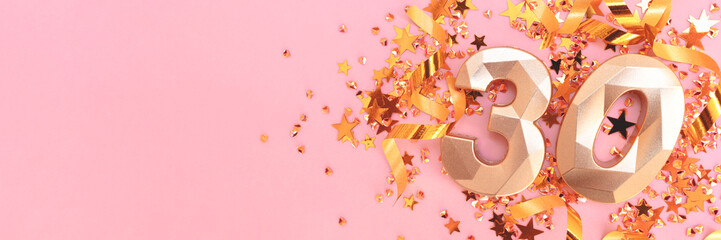 Banner with golden number 30, ribbons and stars confetti on a pink background.