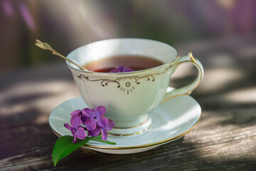 Fototapeta premium A bouquet of lilacs on the table and a cup of tea.