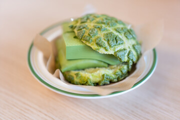 Close-up of matcha cake dessert in Asian Chinese bakery restaurant with warm colors