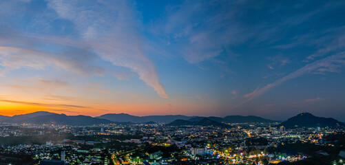 A stunning panoramic view of a coastal city at sunset at Phuket city, showcasing vibrant hues of...