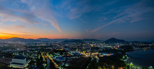 A stunning panoramic view of a coastal city at sunset at Phuket city, showcasing vibrant hues of...