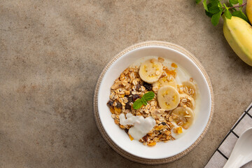 muesli with fresh banana and yoghurt in white bowl.delicious healthy breakfast.Top view.