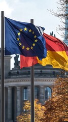 European Union and German national flags wave together in Berlin with historical architecture behind