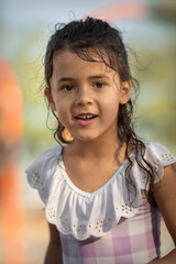 LIttle girl in swimsuit having fun in the park at summer time