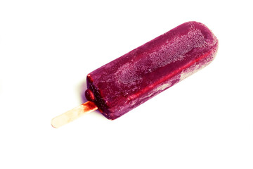 Frozen purple fruit popsicle served on a wooden stick with a smooth, glossy exterior, ideal for a...