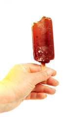 Hand holding a chocolate popsicle showcasing a frozen treat against a white background