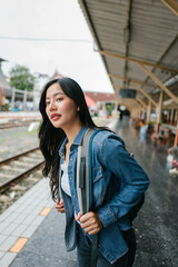 Tourist with backpack standing on platform waiting for train
