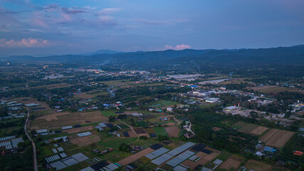 A dramatic view of a lush, forested mountain peak shrouded in thick clouds, capturing the raw...