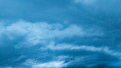 A dramatic view of a lush, forested mountain peak shrouded in thick clouds, capturing the raw...