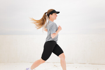 Runner in motion on a bright day showcases determination and energy while exercising against a...