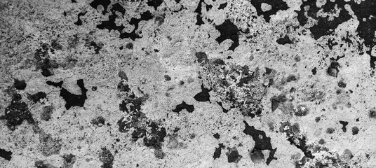 High contrast black and white abstract grunge texture featuring a rough, worn surface with mottled patterns and dark irregular shapes, ideal for backgrounds, overlays, and artistic effects.