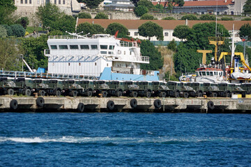 new military vehicles loaded in a harbor