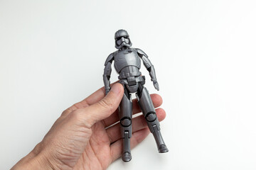 Naklejka premium Hand Holding a Grey Stormtrooper Action Figure