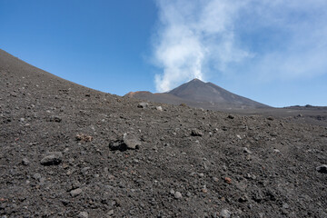 Etna volcano view from the bottom with rocks in foreground