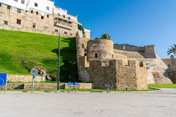 Scenic views of Tangier's seafront and old medina walls on a sunny day, showing a mix of coastal charm, public spaces, and historic Moroccan architecture