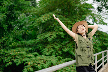Young woman enjoying nature in green surroundings on a sunny day while wearing a hat and casual...