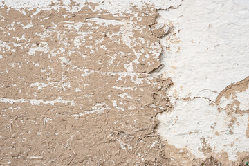 Old cracked clay wall. Long cracks of a rural house