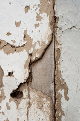 Old cracked clay wall. Deep cracks of a rural house