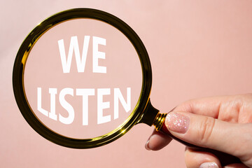 We listen symbol. Concept words We listen on magnifying glass. Beautiful pink background....