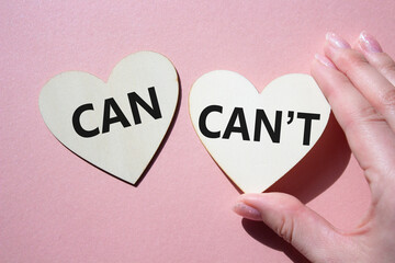 Can or Cant symbol. Concept word Can or Cant on wooden hearts. Businessman hand. Beautiful pink...