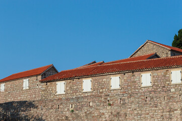 Obraz premium A fragment of the stone medieval fortress of Sveti Stefan island-hotel, on the Adriatic coast, Montenegro. Details