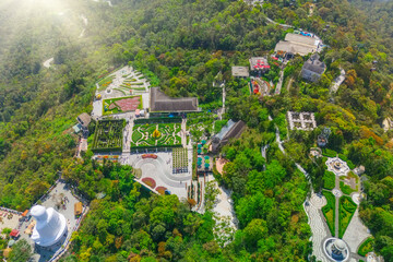 Aerial view panoramic overlook view from the top height of the air park bushes flower beds labyrinths on the mountain slope village streets campuses.