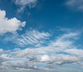 Fototapeta premium Sky panorama filled with a variety of clouds, from fluffy cumulus to wispy cirrus, stretches across the horizon on a bright