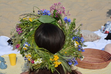 Girl wearing a traditional Ivana Kupala flower crown made of wildflowers and herbs. Midsummer folk...