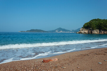 Obraz premium Beach landscape Against the blue sky and azure sea with foam, near Villa Milocer, along the Adriatic coast in Montenegro