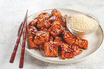 fried pieces of salmon teriyaki with sesame seeds, top view,