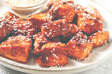 fried pieces of salmon teriyaki with sesame seeds, top view,