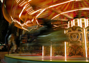 Carousel lights creating swirling patterns of illumination at night.