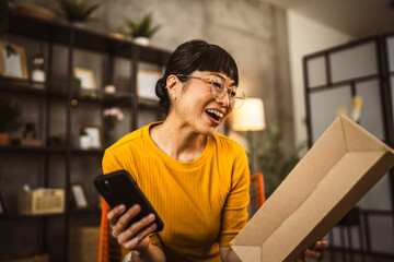 japanese woman checking box of received package or product at home