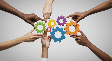 Hands of diverse people interacting with colorful gears on a white background symbolizing teamwork