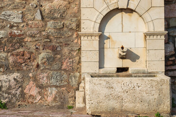 A fragment of the stone medieval fortress of Sveti Stefan island-hotel, on the Adriatic coast,...