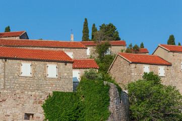 A fragment of the stone medieval fortress of Sveti Stefan island-hotel, on the Adriatic coast, Montenegro. Details. Horizontally