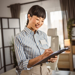 Portrait of japanese mature woman hold clipboard at office